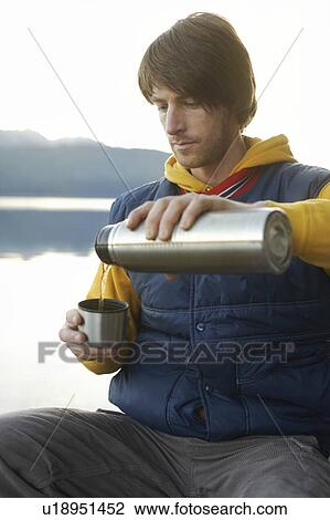 Man on lake in mountains filling his cup View Large Photo Image Stock Image - Man on lake in mountains filling his cup. Fotosearch