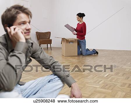 Man on phone while women packs View Large Photo Image Stock Photo - Man on phone while women packs. Fotosearch