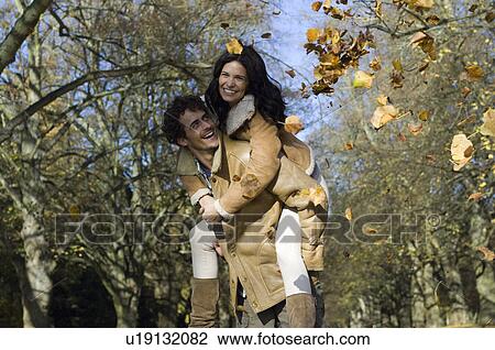 Man on woman's back with leaves View Large Photo Image Stock Image - Man on woman's back with leaves. Fotosearch