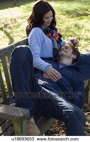 Stock Image - Man on woman's lap relaxing. Fotosearch