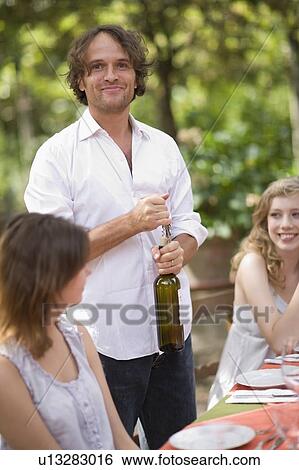 Stock Photograph - Man opening a bottle of wine. Fotosearch