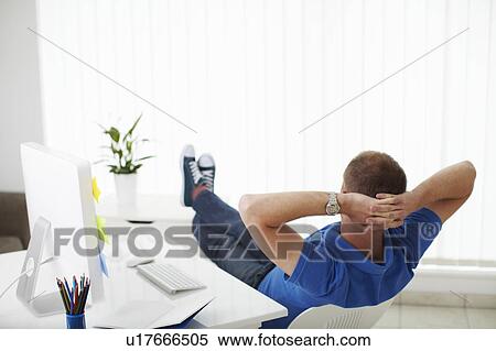 Man reclining on chair next to computer View Large Photo Image Stock Photography - Man reclining on chair next to computer. Fotosearch