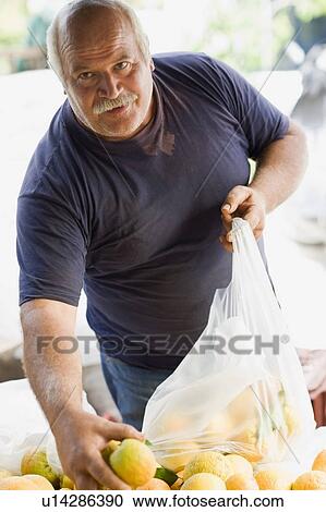Stock Image - Man selling oranges. Fotosearch