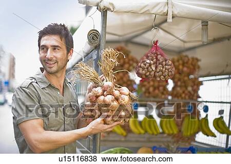 Stock Photo - Man selling vegetables. Fotosearch