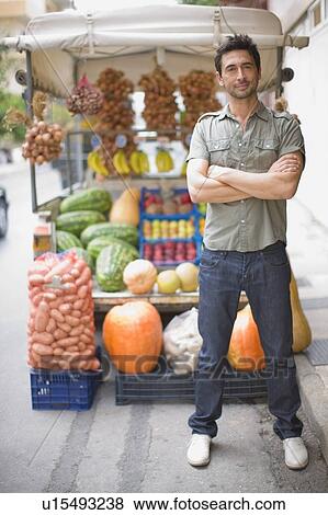Stock Photo - Man standing at market stall. Fotosearch