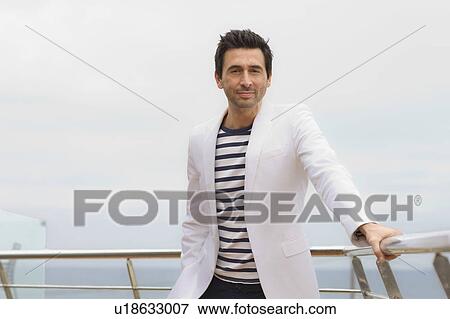 Man standing at railing View Large Photo Image Stock Photo - Man standing at railing. Fotosearch