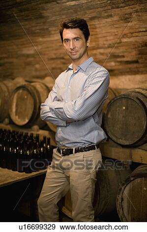 Stock Photo - Man standing in wine cellar. Fotosearch