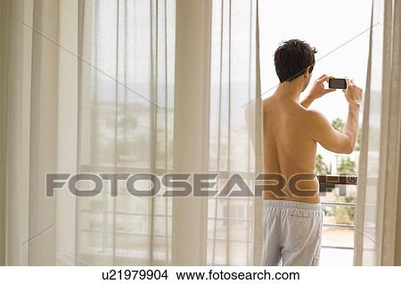 Picture - Man standing on balcony. Fotosearch