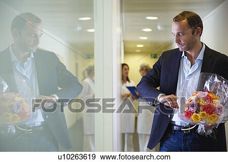 Man with flowers, looking at his watch View Large Photo Image Stock Photo - Man with flowers, looking at his watch. Fotosearch