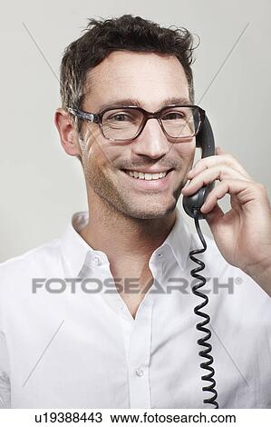Stock Image - Man with glasses on telephone. Fotosearch