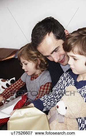 Man with two Kids opening gifts View Large Photo Image Stock Photo - Man with two Kids opening gifts. Fotosearch