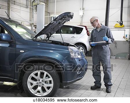 Mechanic analyzing engine View Large Photo Image Stock Photography - Mechanic analyzing engine. Fotosearch