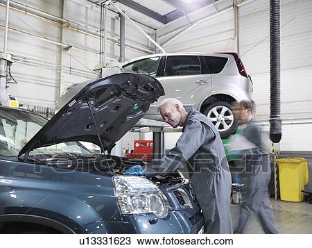 Mechanics working in car dealership View Large Photo Image Stock Image - Mechanics working in car dealership. Fotosearch
