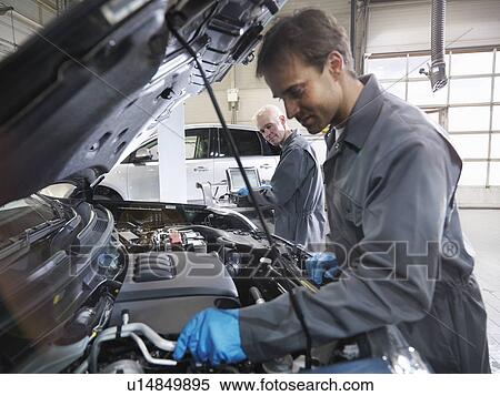 Stock Photography - Mechanics working on engine. Fotosearch