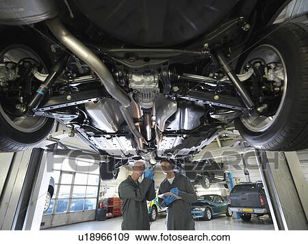 Stock Photo - Mechanics working under car. Fotosearch