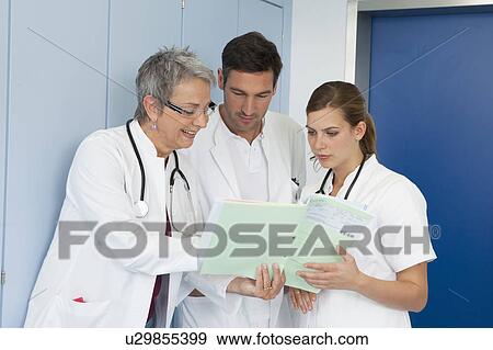 Medical team examinining medical file View Large Photo Image Stock Photo - Medical team examinining medical file. Fotosearch