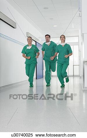 Medical team in scrubs rushing in hall View Large Photo Image Stock Photography - Medical team in scrubs rushing in hall. Fotosearch