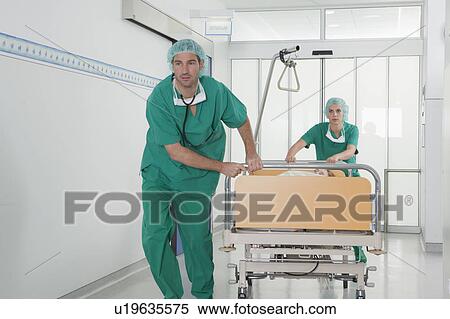 Medical team in scrubs with bed in hall View Large Photo Image Stock Photography - Medical team in scrubs with bed in hall. Fotosearch