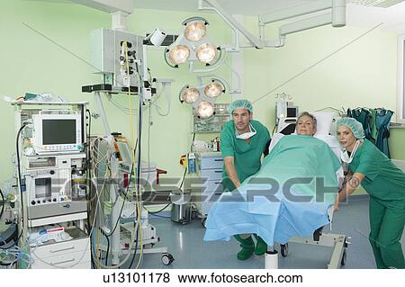 Medical team pushing couch with patient View Large Photo Image Stock Photo - Medical team pushing couch with patient. Fotosearch