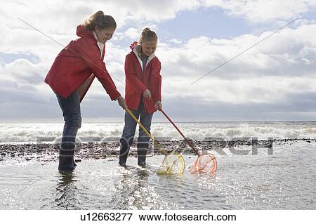 Mother and daughter fishing with fishnet View Large Photo Image Stock Photo - Mother and daughter fishing with fishnet. Fotosearch