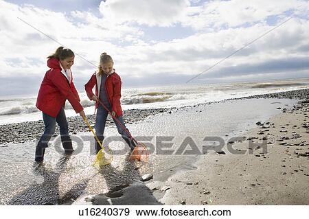 Stock Photo - Mother and daughter fishing with fishnet. Fotosearch