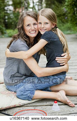 Stock Image - Mother and daughter hugging and smiling. Fotosearch