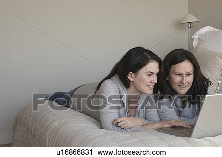 Mother and daughter looking at laptop View Large Photo Image Stock Image - Mother and daughter looking at laptop. Fotosearch