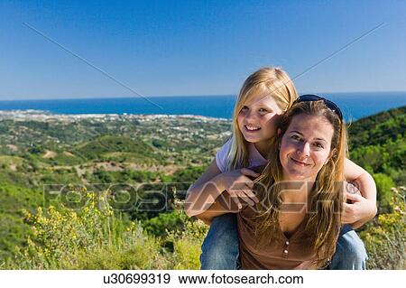 Stock Photo - Mother and daughter piggyback ride. Fotosearch