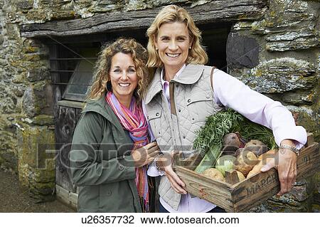 Stock Image - Mother and daughter with vegetables. Fotosearch
