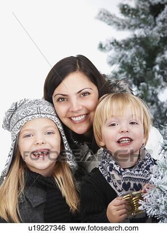 Stock Photograph - Mother and kids by snowy trees. Fotosearch