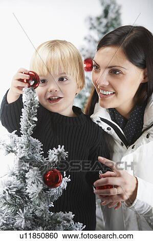 Mother and son decorating a snowytree View Large Photo Image Stock Image - Mother and son decorating a snowytree. Fotosearch