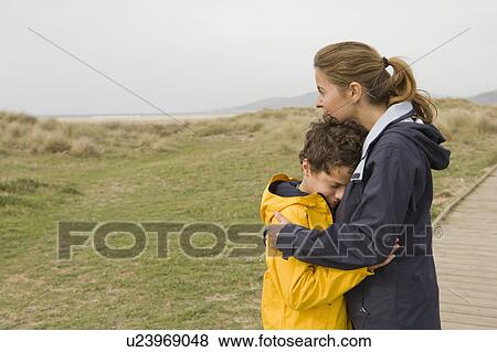 Mother and son hugging on boardwalk View Large Photo Image Stock Photo - Mother and son hugging on boardwalk. Fotosearch