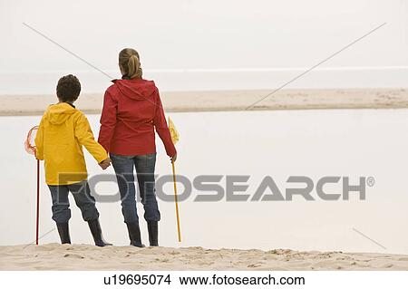 Mother and son on beach with fishing net View Large Photo Image Picture - Mother and son on beach with fishing net. Fotosearch