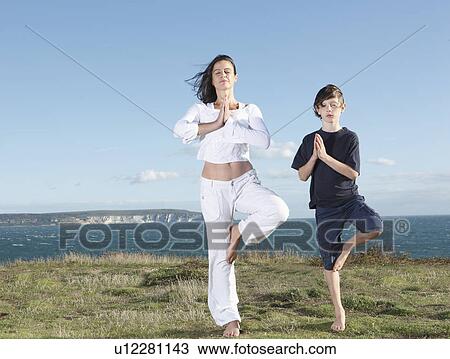 Stock Image - Mother and son practicing yoga. Fotosearch