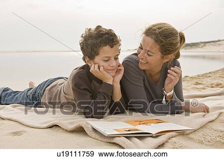 Mother and son reading book at the beach View Large Photo Image Stock Photo - Mother and son reading book at the beach. Fotosearch