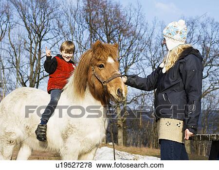 Stock Photo - Mother and son with horse. Fotosearch