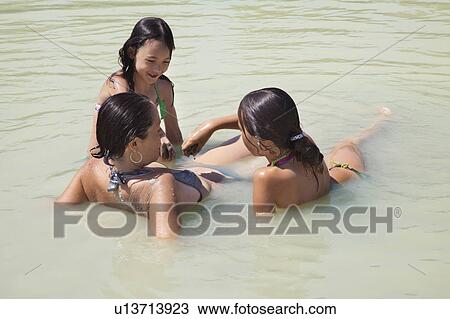 Mother and two girls play in a lake View Large Photo Image Stock Image - Mother and two girls play in a lake. Fotosearch