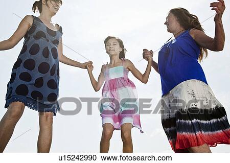 Stock Image - Mother, Grandmother, Daughter jumping. Fotosearch