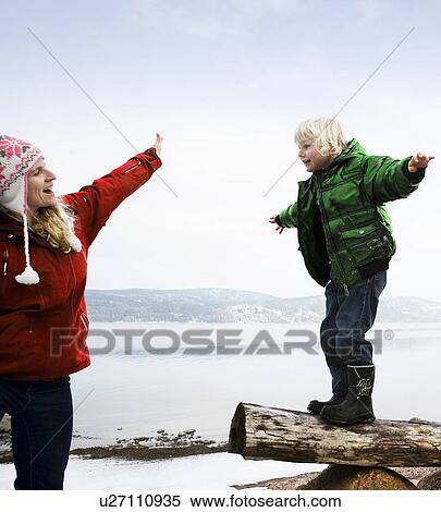 Stock Photography - Mother helping son balancing. Fotosearch