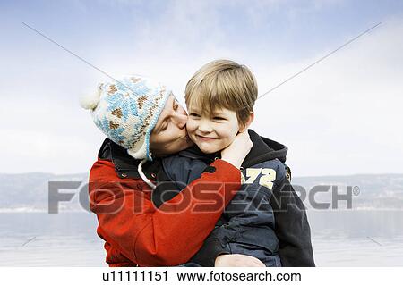 Stock Image - Mother kissing son. Fotosearch