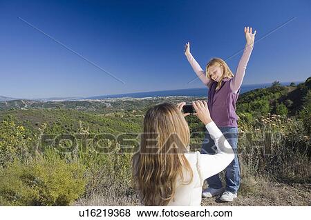 Mother photographing daughter with view View Large Photo Image Stock Photo - Mother photographing daughter with view. Fotosearch