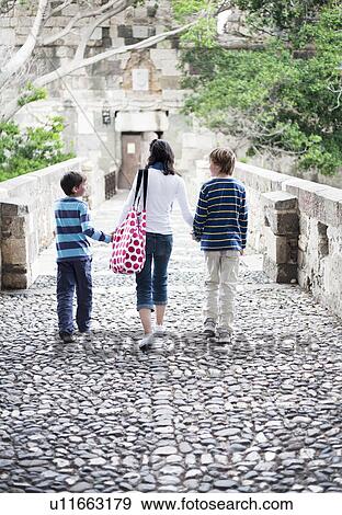 Stock Photo - Mother walking with two boys. Fotosearch