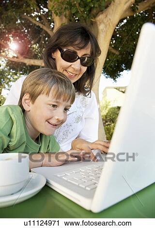 Mum and son looking at laptop View Large Photo Image Stock Image - Mum and son looking at laptop. Fotosearch