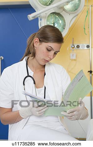 Nurse examining medical file View Large Photo Image Stock Photography - Nurse examining medical file. Fotosearch