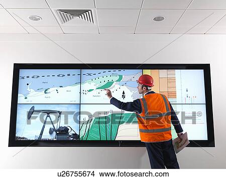 Oil worker with geology screen View Large Photo Image Picture - Oil worker with geology screen. Fotosearch