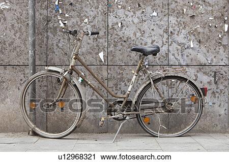 Stock Image - Old bike in front of a weathered wall. Fotosearch