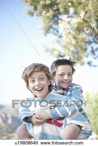One boy piggybacking the other View Large Photo Image Stock Photo - One boy piggybacking the other. Fotosearch
