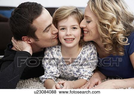 Parents kissing daughter on cheeks View Large Photo Image Stock Photo - Parents kissing daughter on cheeks. Fotosearch