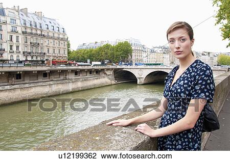 Stock Image - Portrait of woman by river seine Paris. Fotosearch