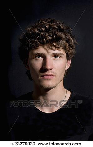 Stock Photo - Portrait young man black background. Fotosearch